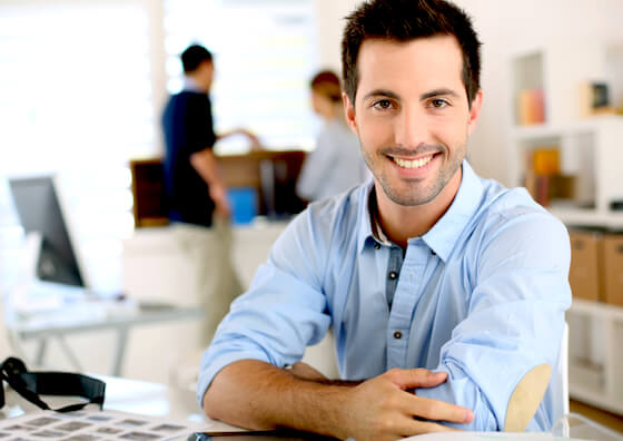 Smiling man with arms crossed in office